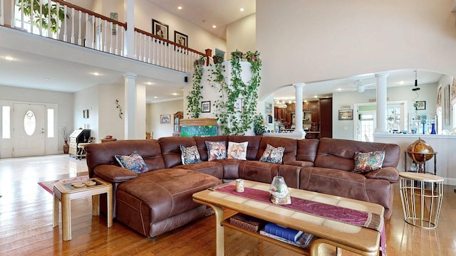 16 Ocean Greens Dr, Saco, ME 04072 - living area featuring decorative columns, a high ceiling, wood-type flooring, arched walkways, and recessed lighting