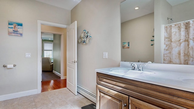 16 Ocean Greens Dr, Saco, ME 04072 - bathroom with baseboards, double vanity, tile patterned floors, baseboard heating, and a sink