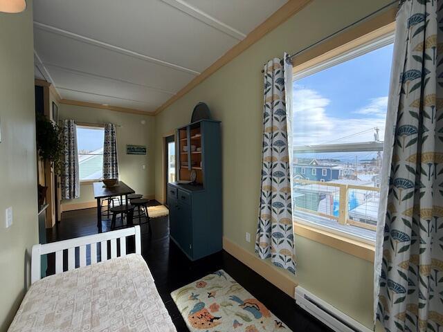 6 School St, Lubec, ME 04652 - dining area with a baseboard radiator, baseboards, ornamental molding, and dark wood-style flooring