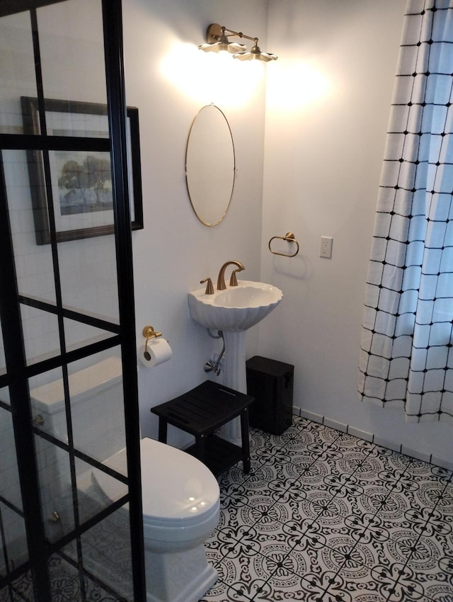 6 School St, Lubec, ME 04652 - full bathroom featuring tile patterned floors, toilet, a sink, a shower with shower curtain, and baseboards