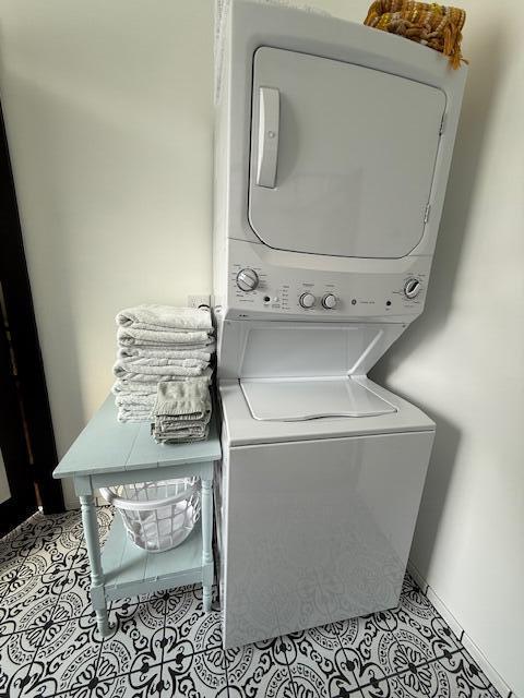 6 School St, Lubec, ME 04652 - clothes washing area featuring light tile patterned floors, stacked washer and clothes dryer, and laundry area