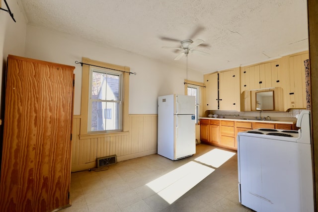 68 Boothby St, Augusta, ME 04330 - kitchen with light floors, a wainscoted wall, visible vents, and white appliances