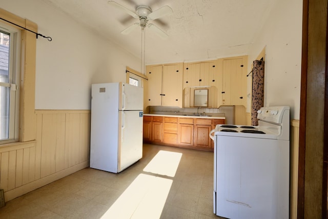 68 Boothby St, Augusta, ME 04330 - kitchen featuring a wainscoted wall, white appliances, a ceiling fan, light floors, and a sink
