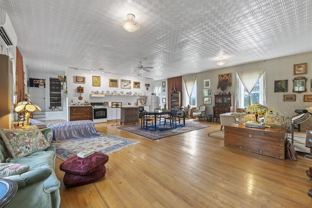 696 Bangor Rd, Troy, ME 04987 - living room with an AC wall unit, light wood-type flooring, and ceiling fan