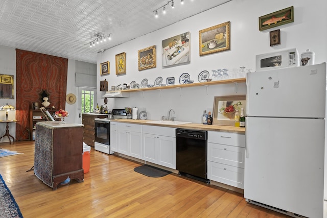 696 Bangor Rd, Troy, ME 04987 - kitchen featuring white appliances, light wood finished floors, a sink, under cabinet range hood, and white cabinetry