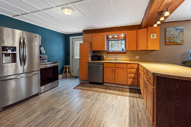 16 Libby Hill Rd, Gardiner, ME 04345 - kitchen with stainless steel appliances, a sink, light wood finished floors, and a peninsula