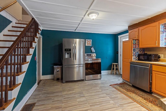 16 Libby Hill Rd, Gardiner, ME 04345 - kitchen with stainless steel appliances, baseboards, light wood-style flooring, and light brown cabinetry