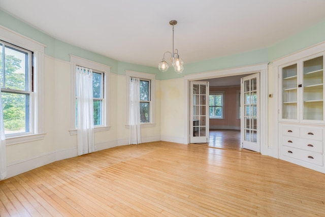 493 Main St, Eliot, ME 03903 - empty room with wood-type flooring, a chandelier, and baseboards
