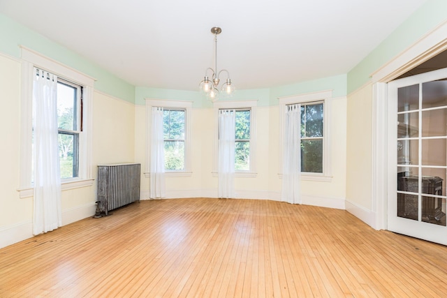 493 Main St, Eliot, ME 03903 - spare room with radiator heating unit, wood-type flooring, a chandelier, and baseboards