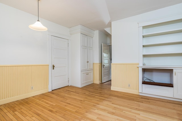 493 Main St, Eliot, ME 03903 - unfurnished bedroom with wainscoting, light wood-type flooring, and multiple closets