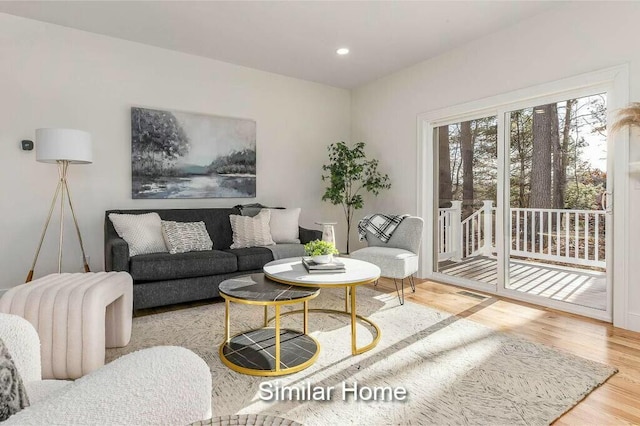 living area with recessed lighting, visible vents, and wood finished floors