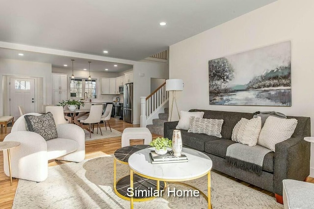 living area with stairs, light wood-style flooring, and recessed lighting