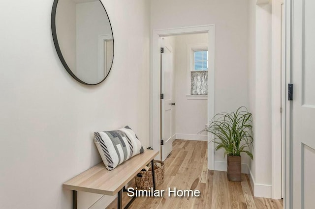 hallway featuring baseboards and light wood-style flooring