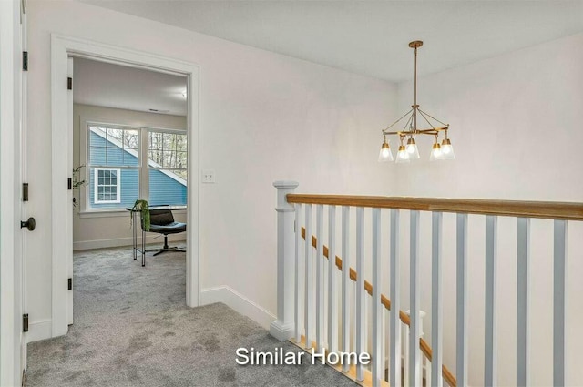 hall with baseboards, an upstairs landing, carpet floors, and an inviting chandelier