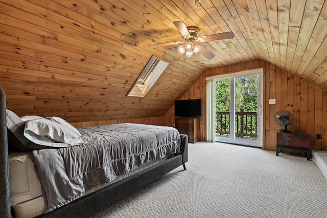 carpeted bedroom featuring access to exterior, vaulted ceiling with skylight, wood ceiling, wood walls, and ceiling fan