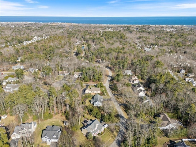 aerial view featuring a residential view, a wooded view, and a water view