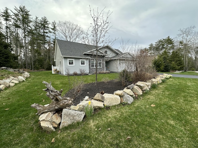 view of home's exterior with a lawn and roof with shingles