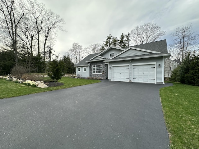 view of front of house with an attached garage, a shingled roof, a front yard, and aphalt driveway