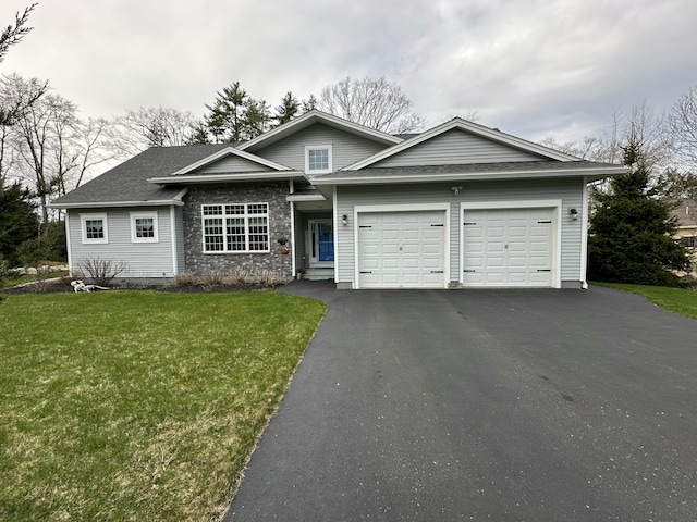 view of front facade with an attached garage, a front yard, aphalt driveway, and roof with shingles