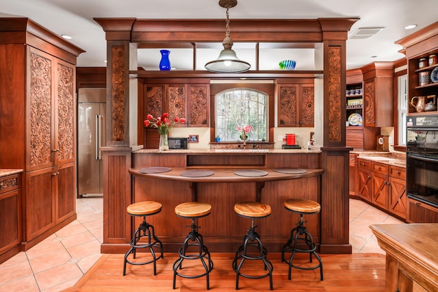 8 Spruce Point Rd, Kittery, ME 03904 - bar with light tile patterned floors, dobule oven black, decorative columns, and high end refrigerator