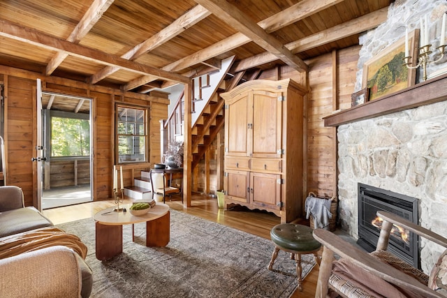 living room featuring wooden walls, beam ceiling, and wood ceiling