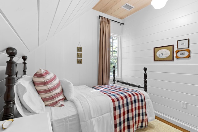 bedroom with visible vents, wood finished floors, and wooden ceiling