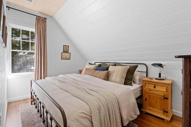 bedroom with lofted ceiling and hardwood / wood-style floors