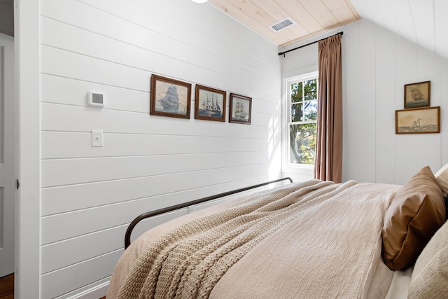 bedroom featuring wood walls, vaulted ceiling, wood ceiling, and visible vents