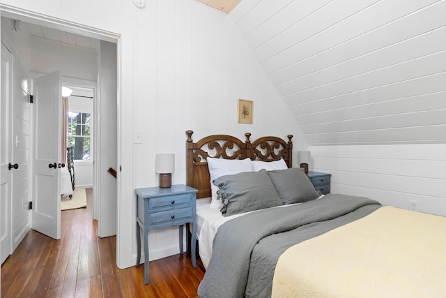 bedroom featuring dark wood finished floors and lofted ceiling