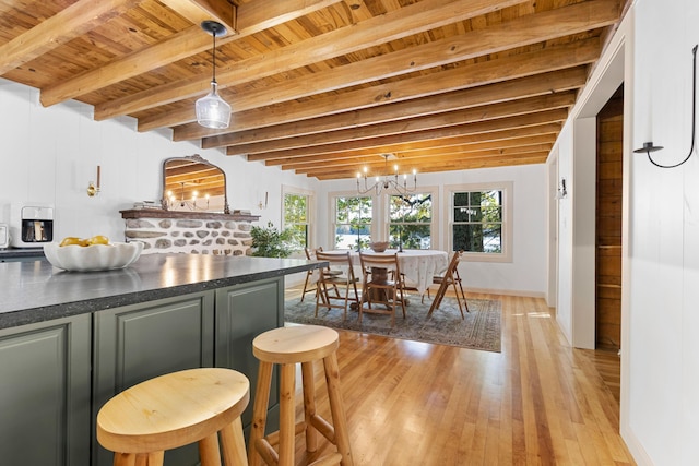 interior space with wood ceiling, baseboards, beamed ceiling, a notable chandelier, and light wood-style flooring