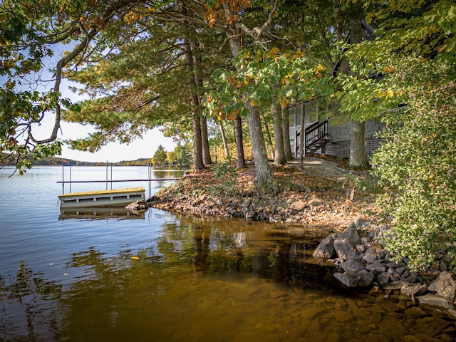 dock area featuring stairway and a water view