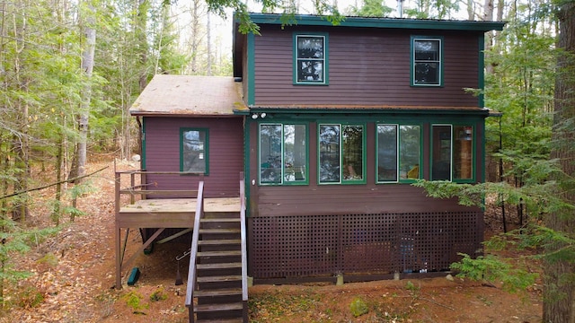 rear view of property with a sunroom, a wooden deck, and stairway
