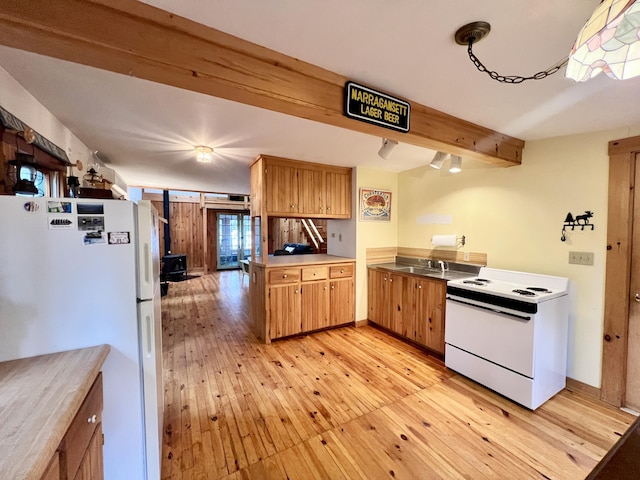 kitchen with beamed ceiling, light wood finished floors, a peninsula, and white appliances