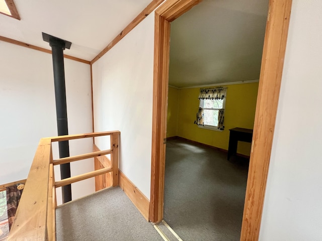 corridor with an upstairs landing, carpet floors, and baseboards