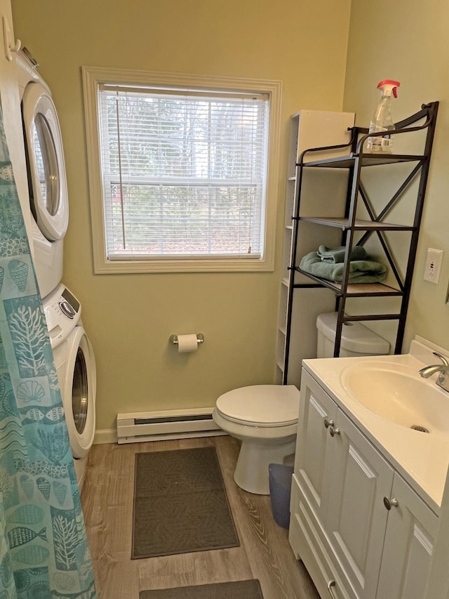 25 Garland Rd, Casco, ME 04015 - full bath featuring stacked washing maching and dryer, toilet, wood finished floors, and a baseboard radiator