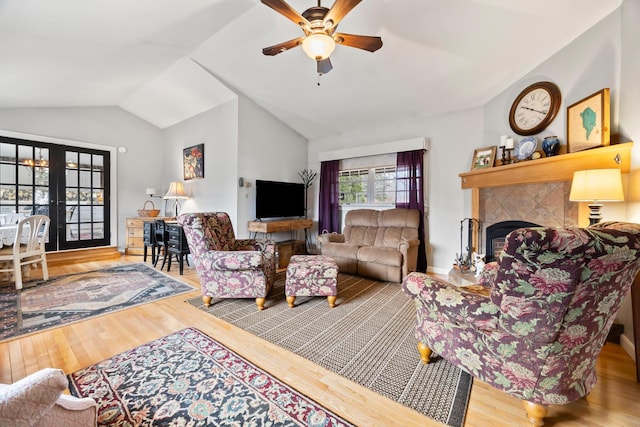663 Eastbrook Rd, Eastbrook, ME 04634 - living area featuring wood finished floors, lofted ceiling, a ceiling fan, french doors, and a tiled fireplace