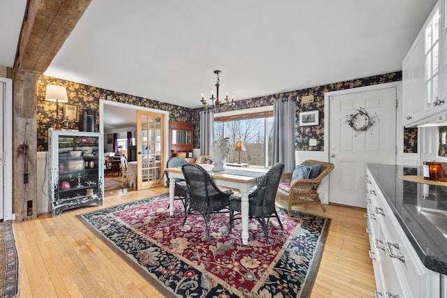 663 Eastbrook Rd, Eastbrook, ME 04634 - dining space with wallpapered walls, a chandelier, and light wood-style flooring