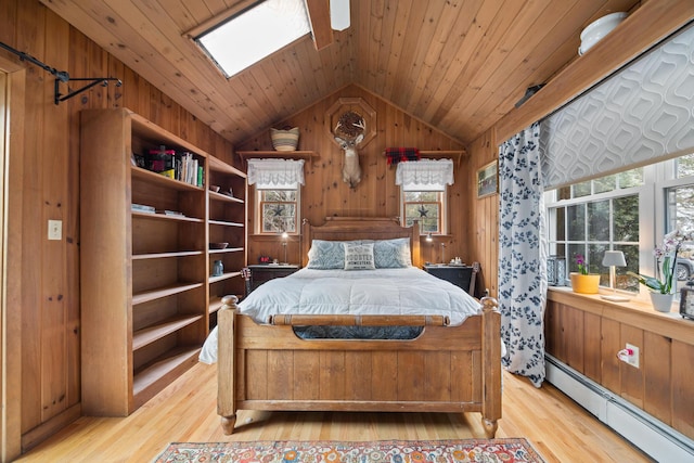 663 Eastbrook Rd, Eastbrook, ME 04634 - bedroom with baseboard heating, lofted ceiling, light wood-type flooring, wood walls, and a skylight