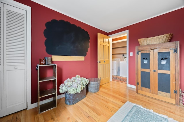 663 Eastbrook Rd, Eastbrook, ME 04634 - living area featuring washing machine and dryer, wood finished floors, crown molding, and baseboards