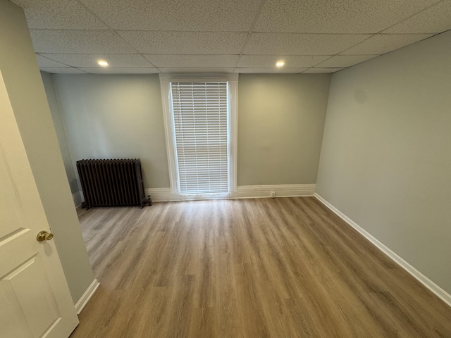 64 Gray St, Portland, ME 04102 - empty room featuring radiator, a drop ceiling, wood finished floors, baseboards, and recessed lighting