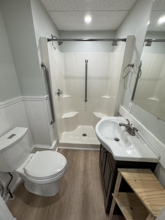 64 Gray St, Portland, ME 04102 - full bathroom featuring wood finished floors, toilet, walk in shower, vanity, and a wainscoted wall