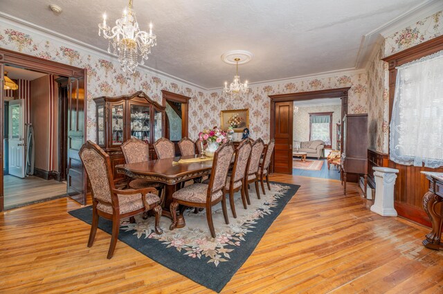 1135 E Pittston Rd, Pittston, ME 04345 - dining room with wallpapered walls, an inviting chandelier, light wood-type flooring, and ornamental molding