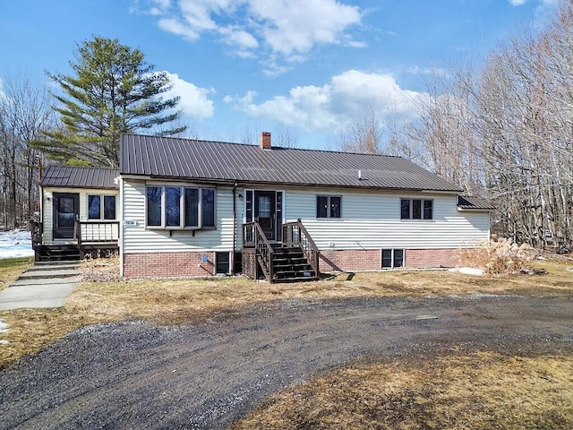 view of front of house with a chimney and metal roof