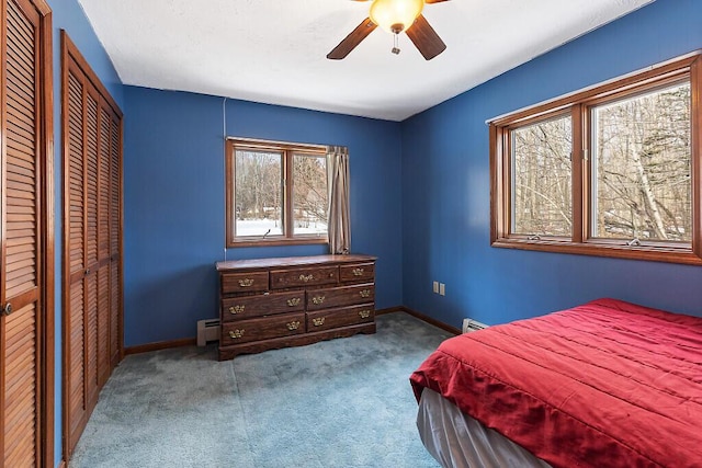carpeted bedroom featuring a baseboard heating unit, a ceiling fan, baseboards, and baseboard heating