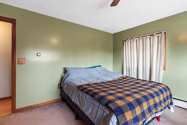 bedroom featuring a baseboard heating unit, baseboards, a ceiling fan, and carpet flooring