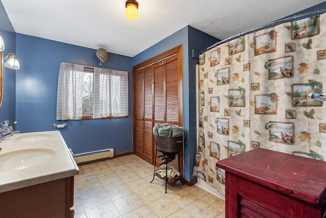 bathroom with double vanity, baseboard heating, baseboards, and a sink