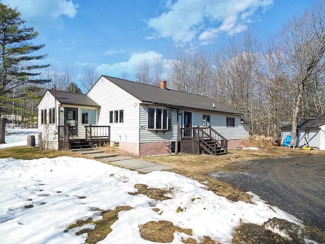 view of front of home with metal roof and a chimney
