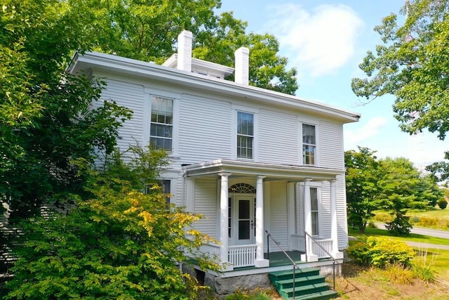 view of front facade featuring a porch and a chimney