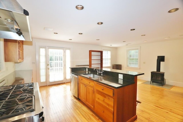 kitchen featuring a sink, dark countertops, appliances with stainless steel finishes, and light wood-style flooring