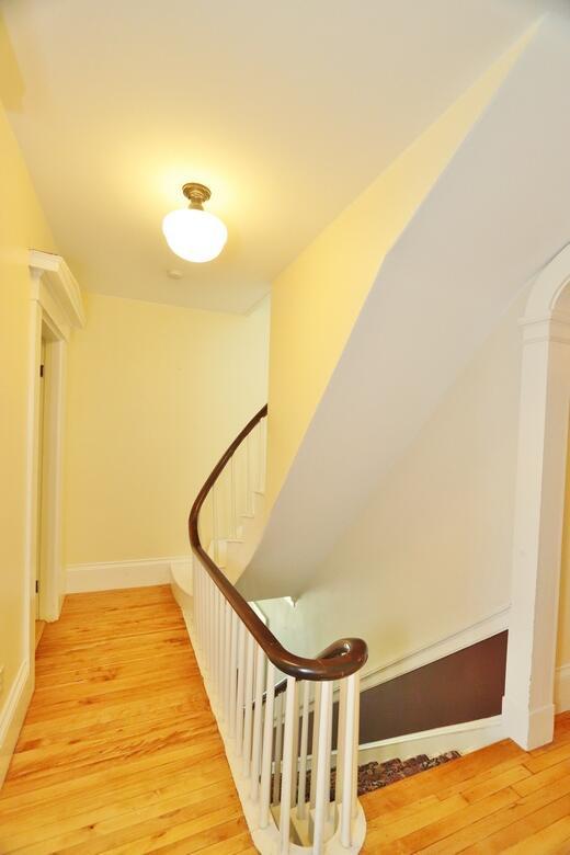 stairway with wood finished floors and baseboards